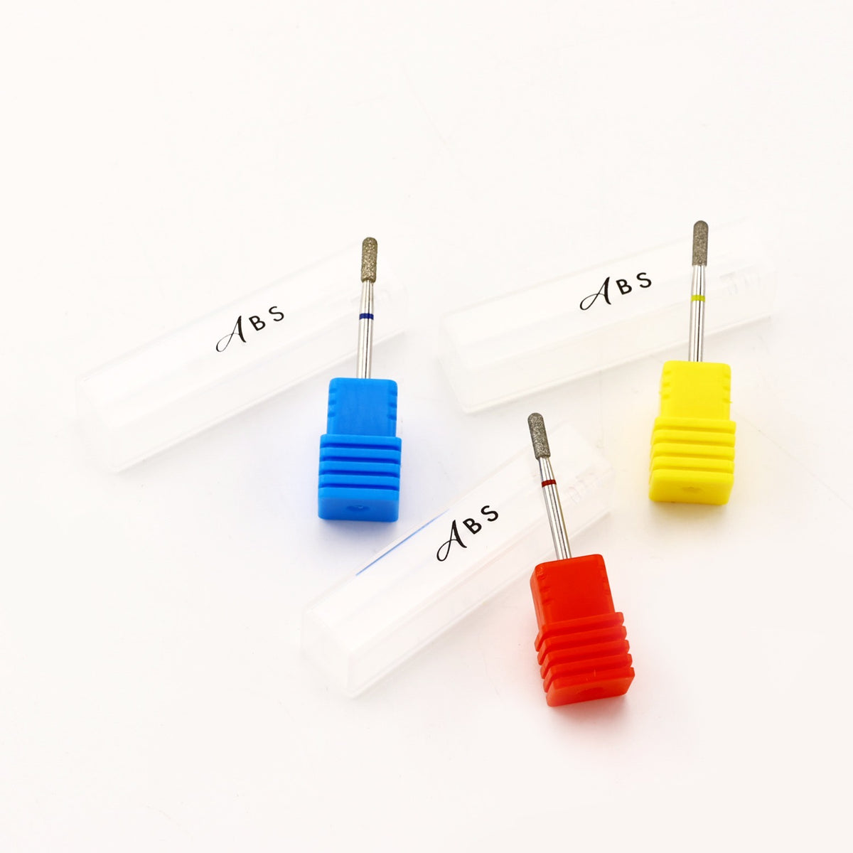 Four dental drill bits with white plastic protective cases, shown in blue, red, and yellow color options on a white background. The cases are labeled with 'Abs' in black script.